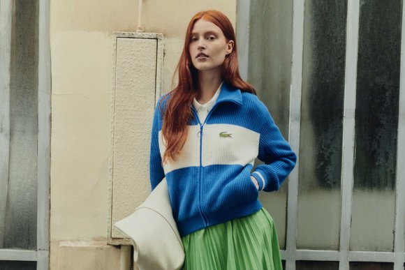 Woman in Lacoste outfit with green tennis skirt and sports jacket